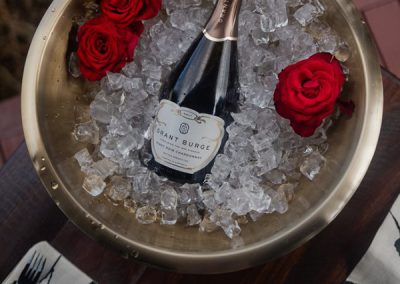 luxury tent / Glamping bottle of bubbles in bowl of ice and rose petals